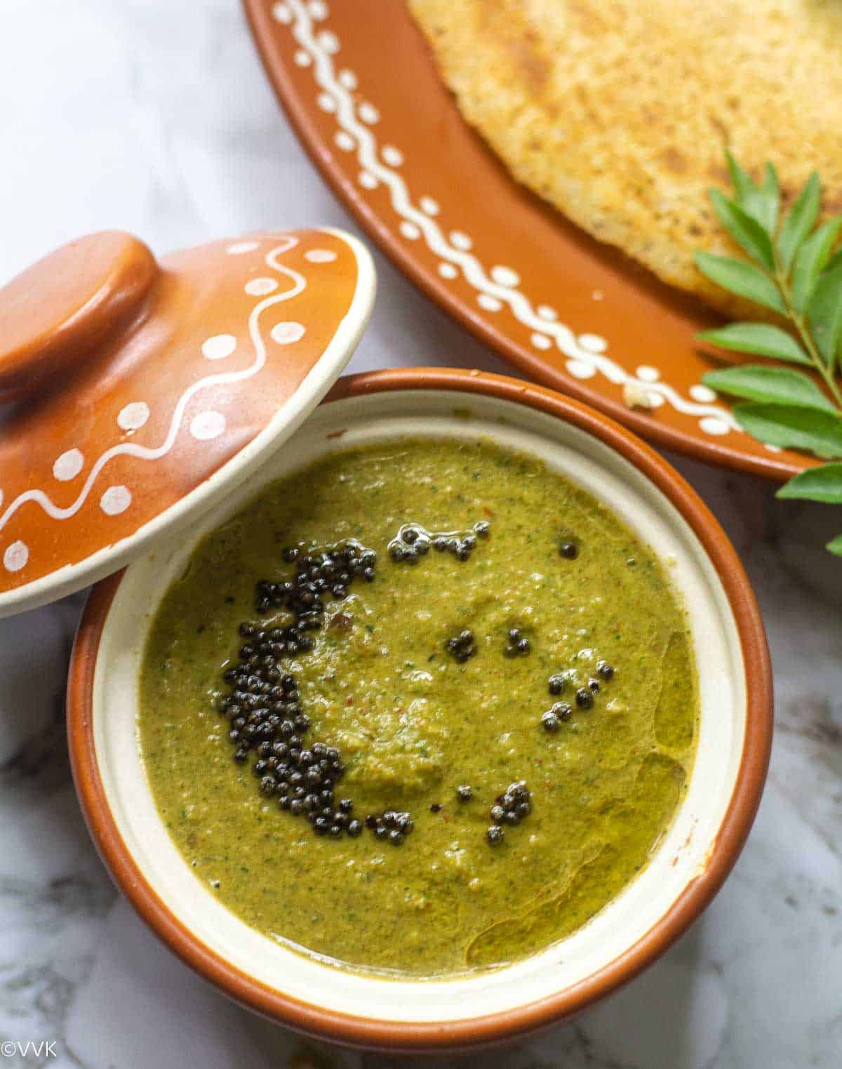 close up shot of curry leaves chutney served with dosa