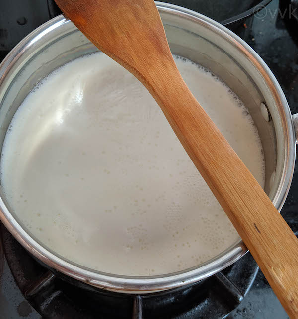 keeping wooden spoon on top to prevent milk overflowing