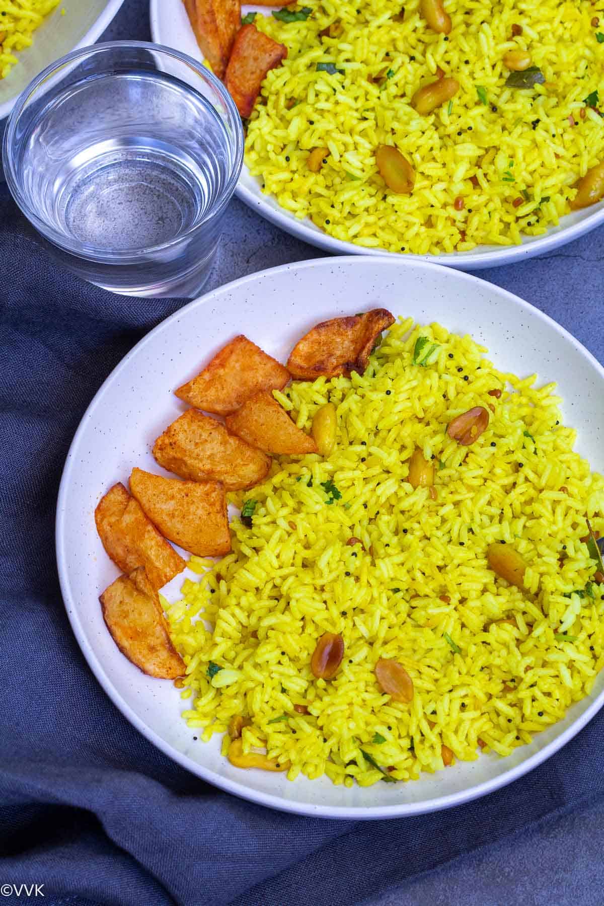 lemon rice served with potato curry with water in the side
