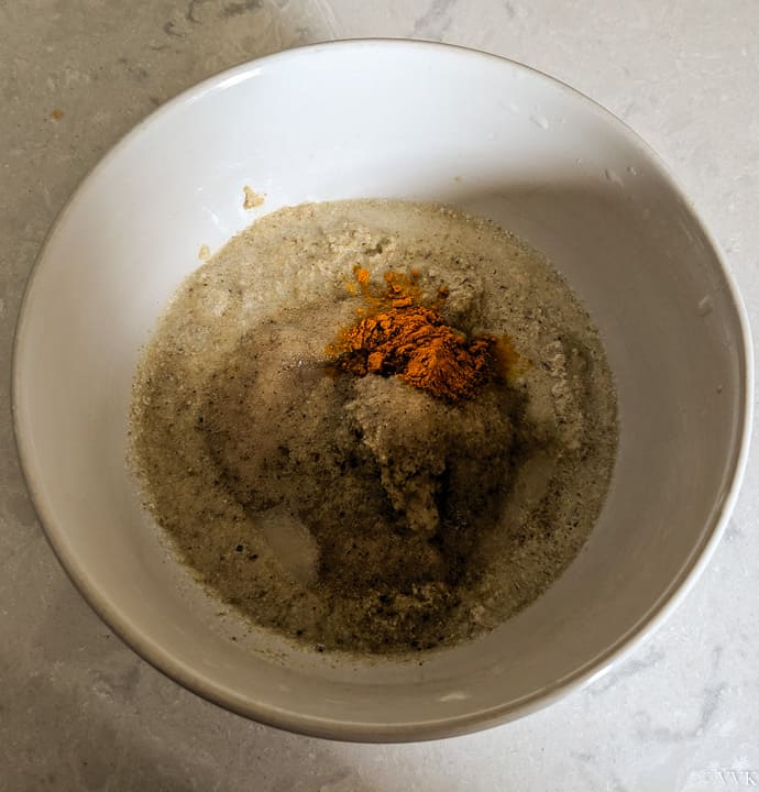 adding salt and turmeric to the ground paste