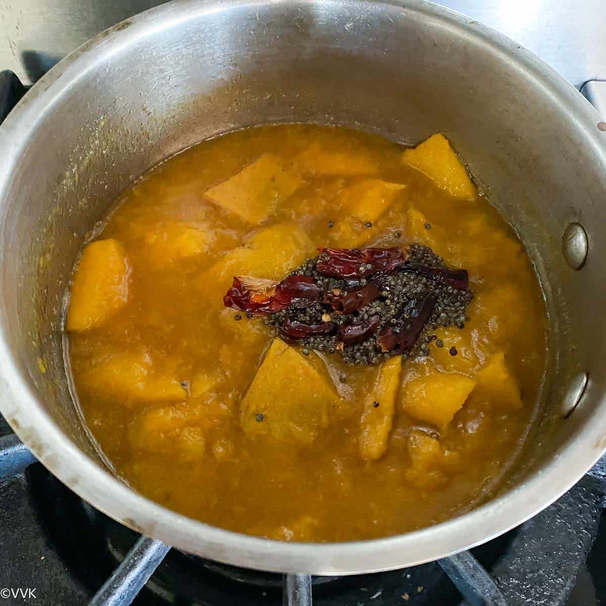 adding the tempering to the mango pachadi