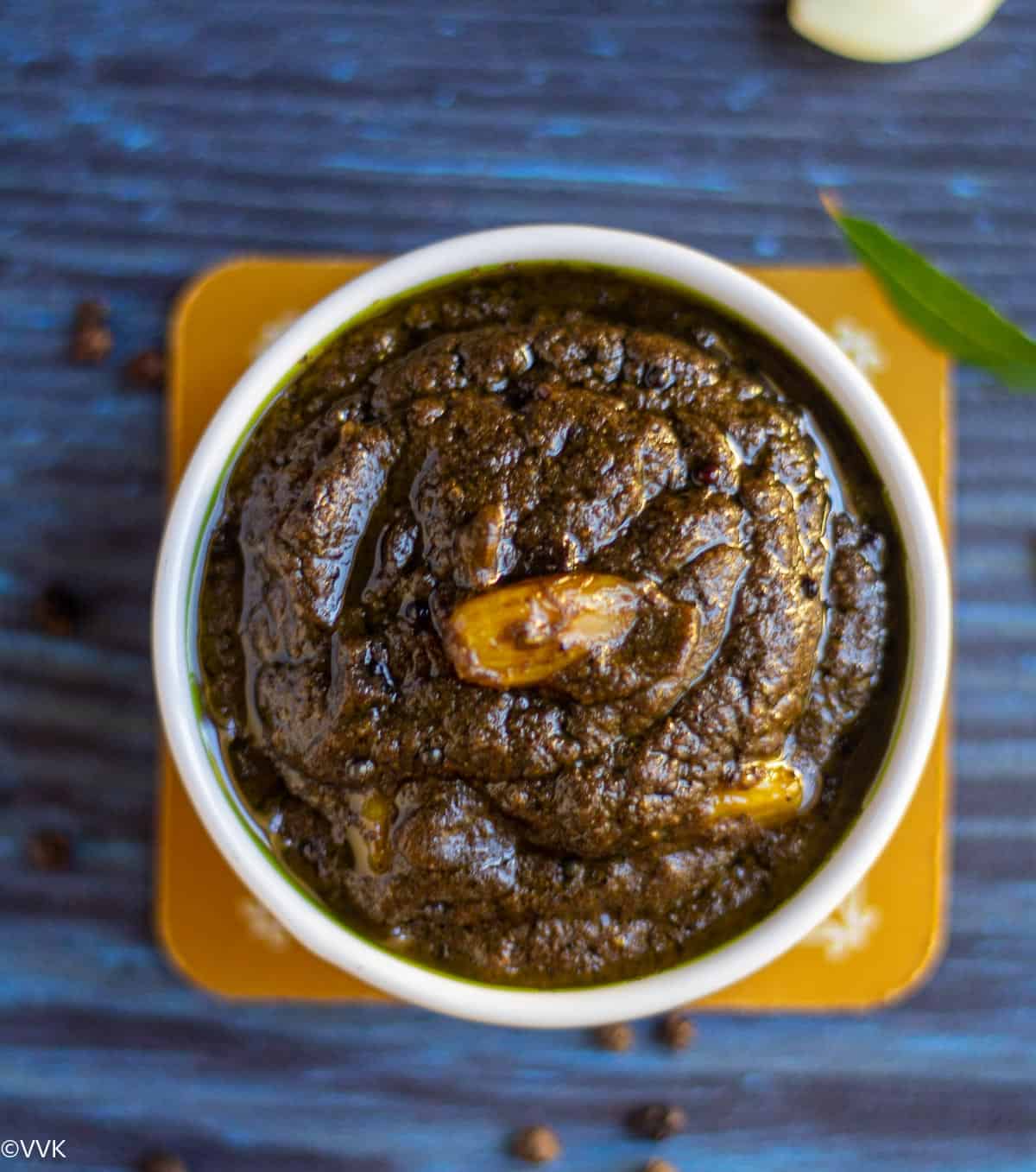 overhead shot of milagu kuzhambu topped with garlic