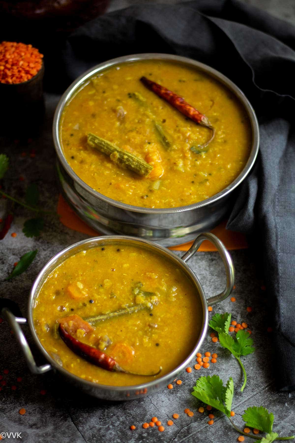 pressure cooker sambar served in stain less steel containers with masoor dal on the side