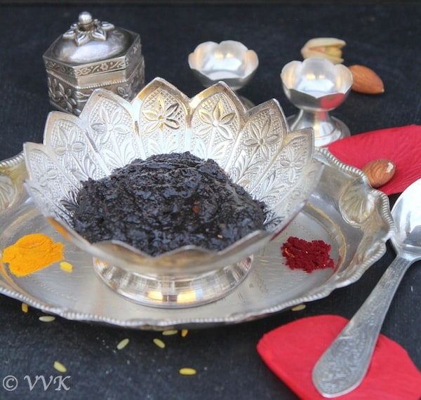 Deepavali Legiyam or Deepavali Marundu served on a metal tray with a metal spoon on top of the pink petals