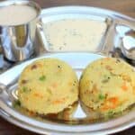 Rava Kichadi served with coconut chutney in a metal tray with a spoon on the side