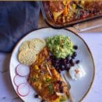 enchilada served with guac, beans and sour cream with text overlay for pinterest