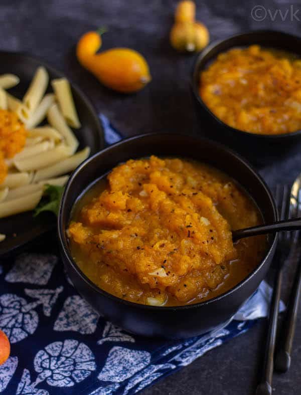 butternut squash pasta sauce in a black bowl with a black spoon