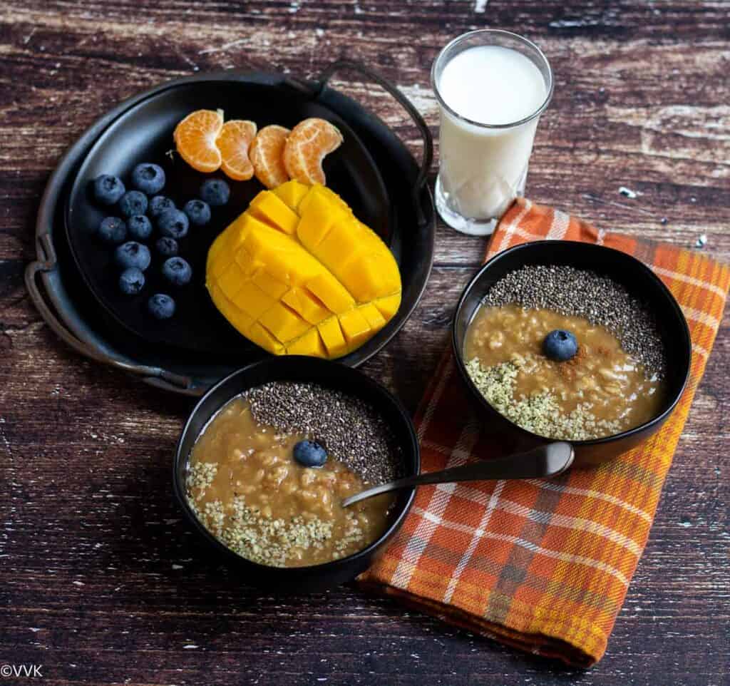 oatmeal topped with hemp seeds, chia seeds served with fruits and milk