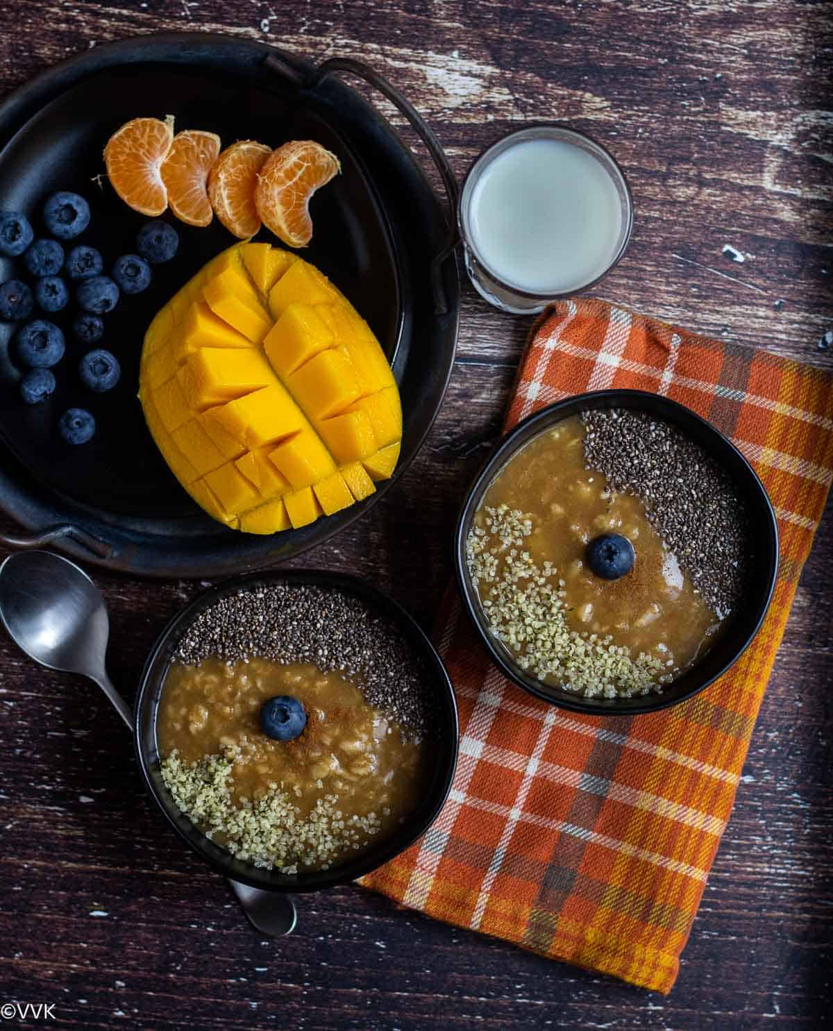 overhead shot of oatmeal served with fruits and milk