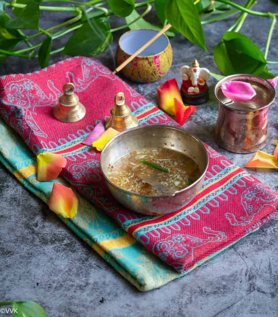 ugadi pachadi served in silver bowl on two napkins and flowers on the side