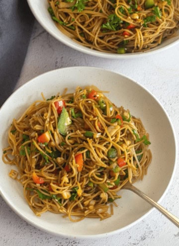 square image of pasta salad served in a bowl with spoon inside