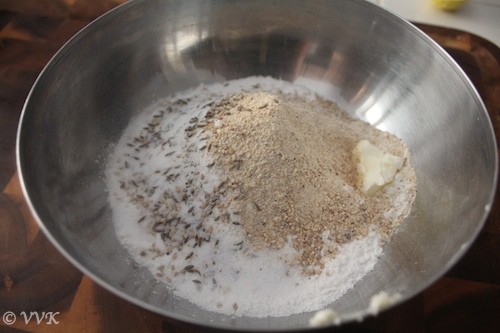 Mixing the rice flour, urad dal flour, jeera, hing, cumin seeds and other ingredients
