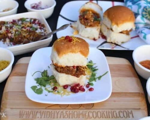 Dabeli Sandwich looking extra inviting and served with pomegranate seeds on a white plate