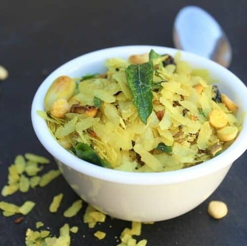 Chivda or Namkeen Chiwda aka the Bombay Mix ready and served in a small white bowl with a spoon on the side