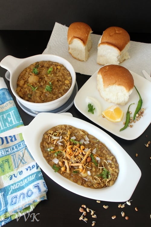 Healthy Missal Pav served in two types of white bowl with bread, lemon and chilis on the side