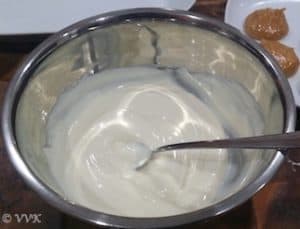 Stirring the melted white chocolate with a spoon in a bowl