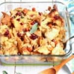 Vegetarian Bread Stuffing Thanksgiving recipe in a big glass casserole with wooden spoons on the side
