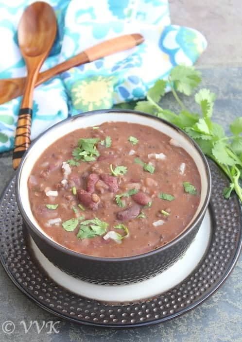 Slow Cooker Vegan Dal Makhani served in a big greyish bowl with two wooden spoons right next to it