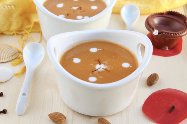 Closeup on the inviting Vegan Carrot Kheer or Carrot Payasam decorated with various ingredients and served with a spoon