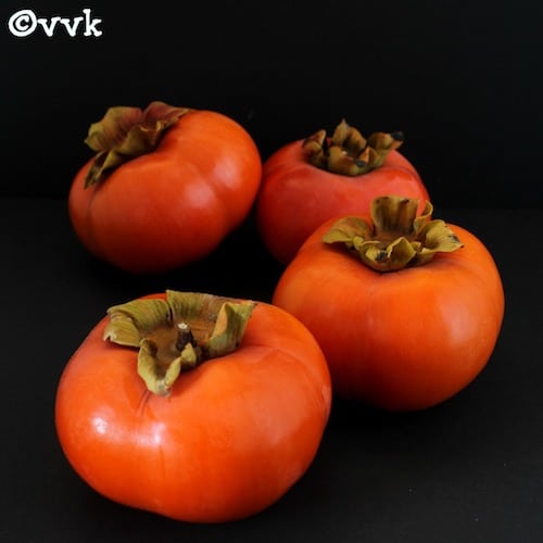 Four persimmons with the dark black background