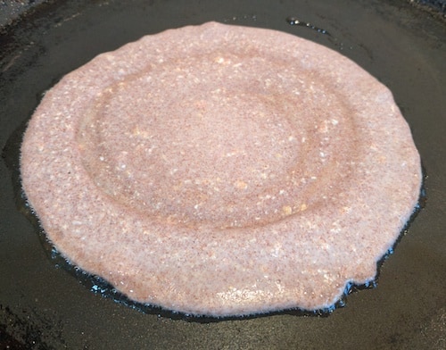 Heating the tawa or griddle and pour about one ladleful of batter and spreading the malpua slightly