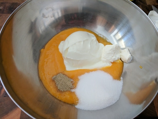 Adding Greek Yogurt, mango puree, sour cream, sugar and cardamom powder