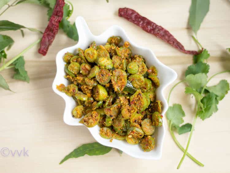 Dondakaya Kobbari Vepudu or Ivy Gourd Coconut Curry served with red chilli and parsley around the bowl