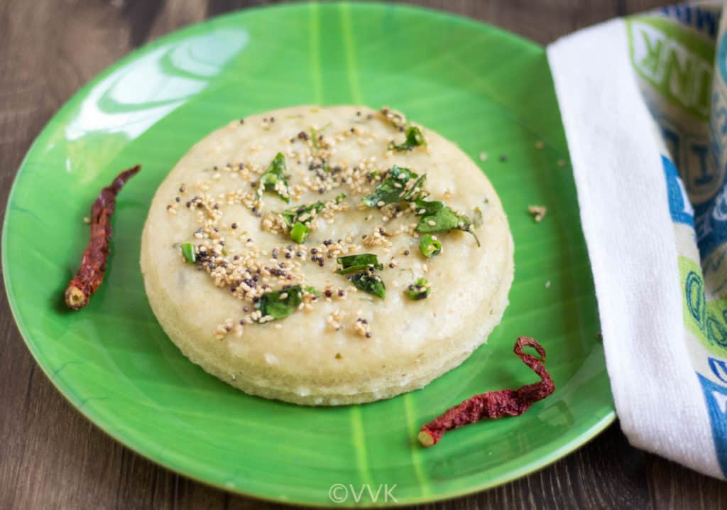 Garnishing the dhokla with cilantro and serving it with green chutney and sweet chutney