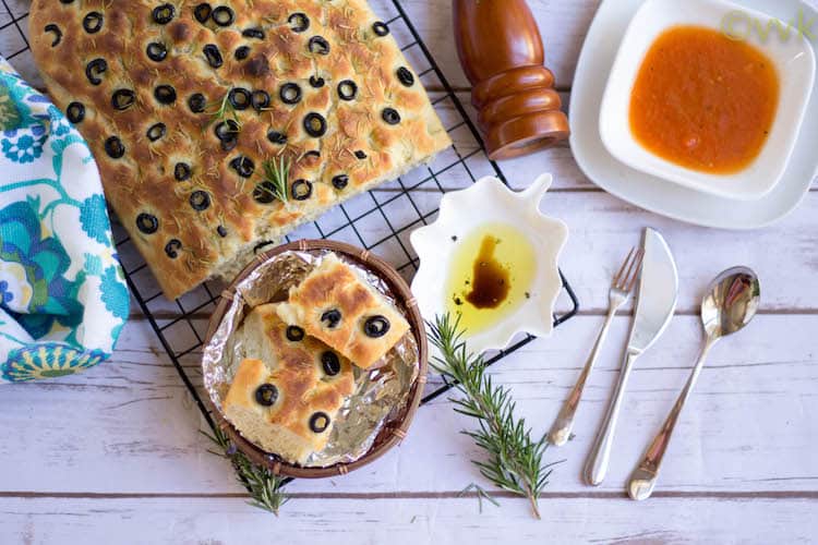 Focaccia Bread with Olives and Rosemary served with a dip and seasoning