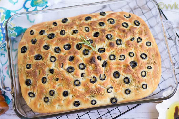Closeup on the delicious Focaccia Bread with Olives and Rosemary sitting in a tray and looking absolutely inviting
