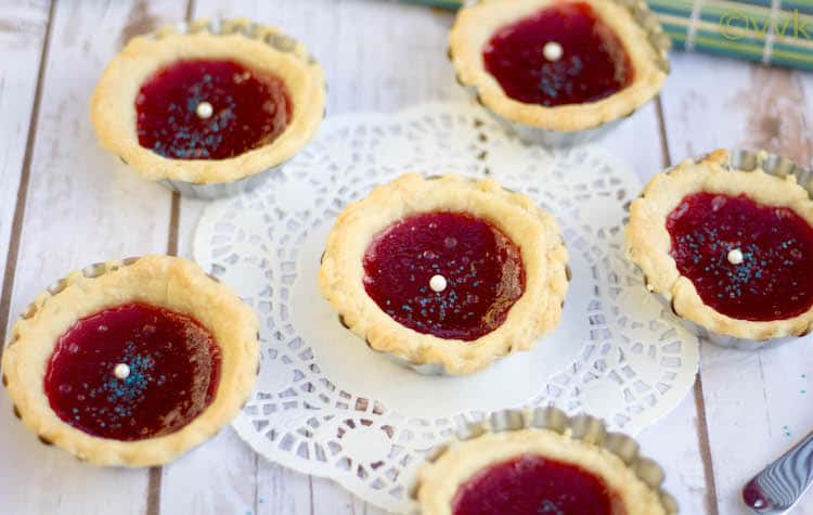 Six Strawberry Jam Tarts served on a white wooden table