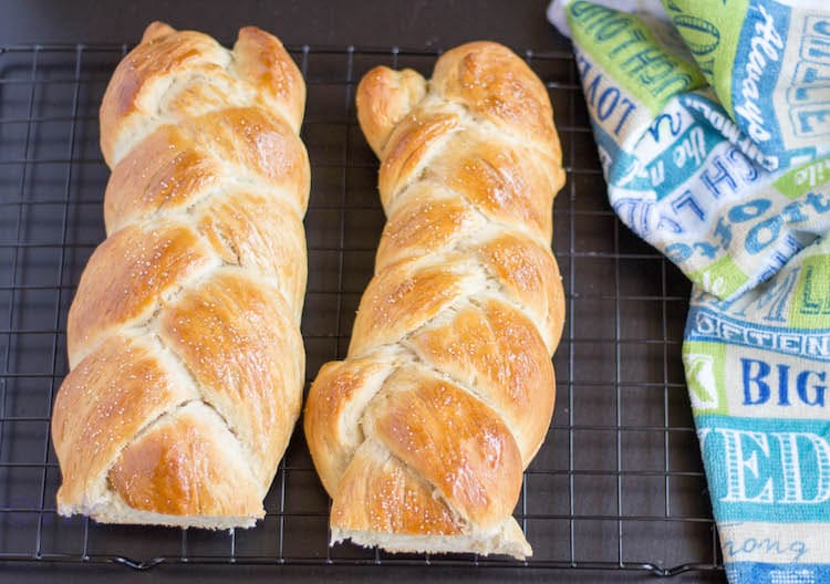 Braided Eggless Challah Bread ready and served with a big colorful towel to the right