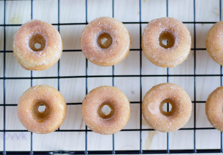 Six Eggless Baked Mini Donuts on a metal net with two more on the right side