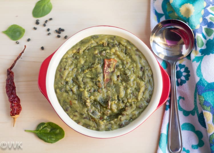 Instant Pot Dal Sagga, or Spinach and Lentils Gravy, is ready and served in a red pan with a scoop on the side