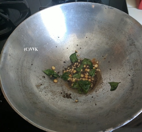 Adding mustard seeds, urad dal, channa dal, hing and curry leaves
