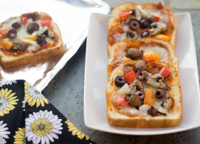 Vegetable Bread Pizza served in white plates on a greyish surface
