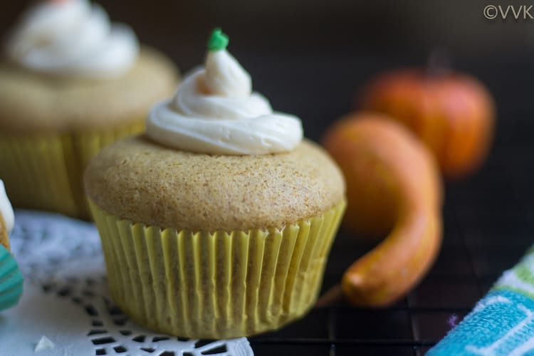 Focus on the Eggless Pumpkin Pie Cupcakes with pumpkins in the backgorund