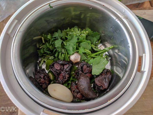 Grinding the soaked kokum pods, cilantro, garlic and green chili