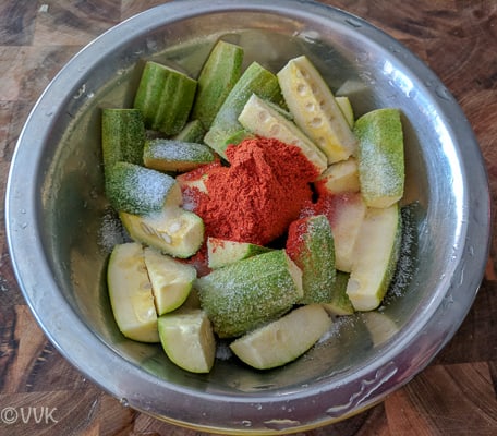 Adding the salt and chili powder to the chopped vegetables
