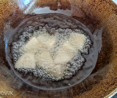 Idli pieces are being fried in the heated oil