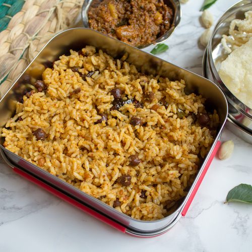 Tamarind Rice or Puliodarai served in a lunchbox with more sides next to it