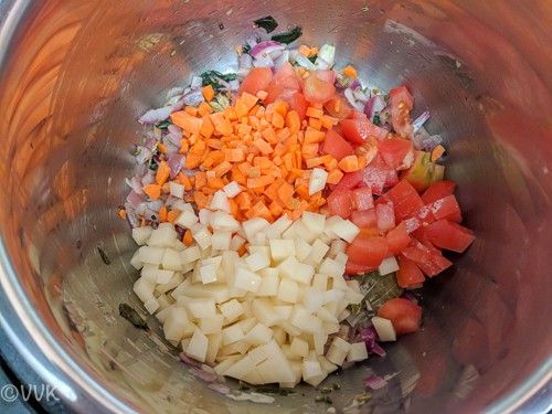 Adding the tomatoes, potatoes and carrots