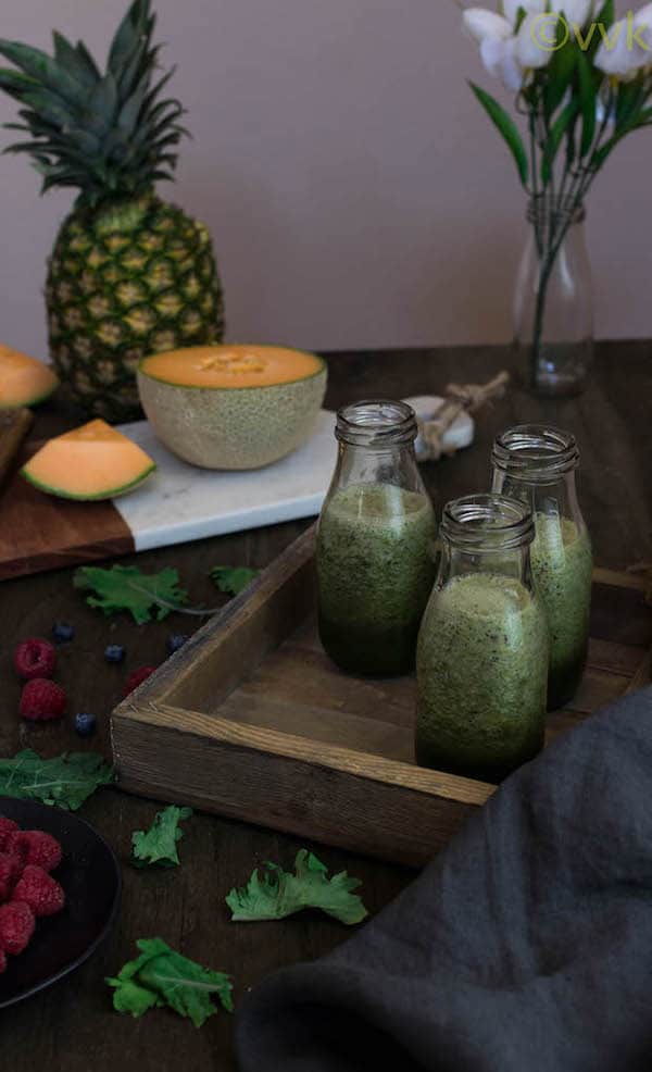 Kale Smoothie with Berries with a pineapple in the background
