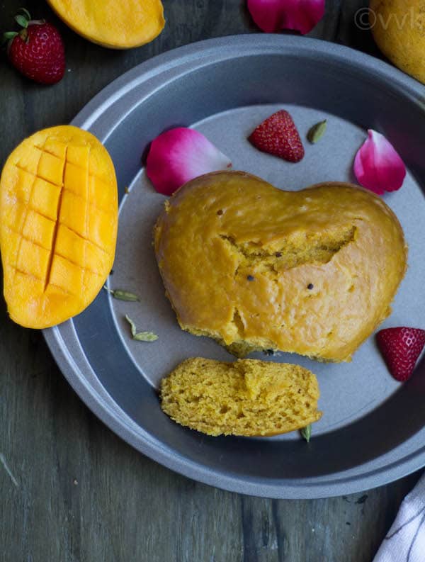 Instant Pot Eggless Mango Cake with a cut piece and a half of a mango next to it