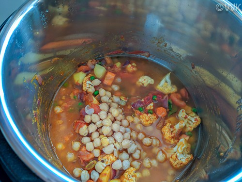 Adding the cooked chickpeas, tomato paste and the two cups of water
