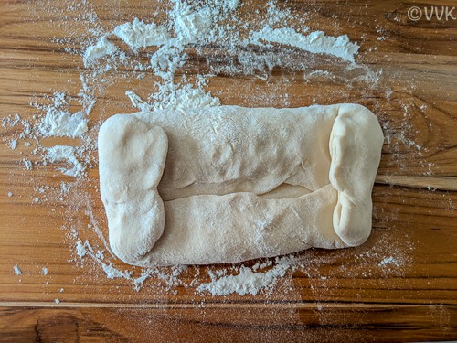 Take the shorter sides of the dough and tucking them in