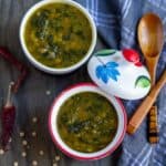 square image of vegan dal palak served in two ceramic bowls