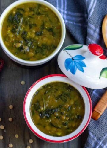 square image of vegan dal palak served in two ceramic bowls
