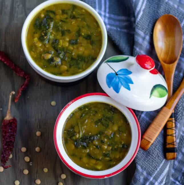 square image of vegan dal palak served in two ceramic bowls