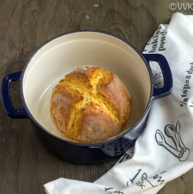 eggless irish soda bread inside dutch oven with a white cloth on the side